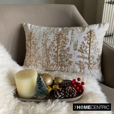 a candle and christmas decorations sit on a tray next to a white fur covered chair