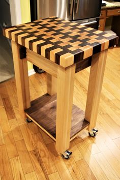 a kitchen island made out of wood with wheels on the bottom and an end table