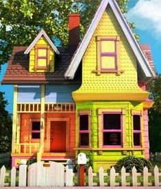 a house painted in bright colors with a white picket fence