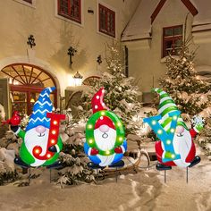 christmas decorations in front of a building with snow on the ground