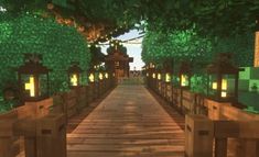 a wooden bridge with lanterns lit up on each side and trees in the back ground