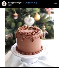 a chocolate cake sitting on top of a white plate next to a christmas ornament