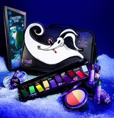 an assortment of cosmetics and makeup products on snow covered ground with blue lighting in background