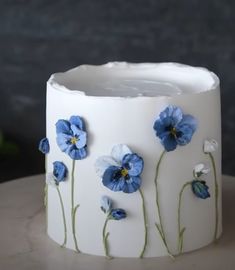 a white vase with blue flowers painted on it