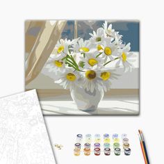 a vase filled with white and yellow daisies next to some colored pencils on a table