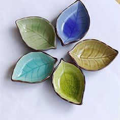 four leaf shaped dishes sitting on top of a table