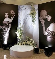 a couple kissing each other in front of two large wall pictures with flowers on them