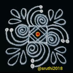 an intricate design made with white thread and orange dot in the center on a black background