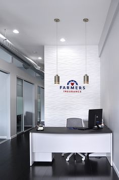 a white desk with a laptop on it in front of a sign that says farmers insurance