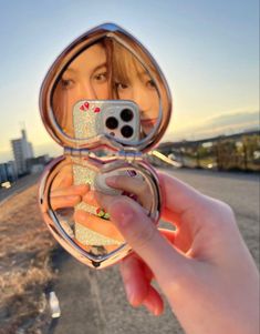 a woman taking a selfie in a mirror with her cell phone up to her face