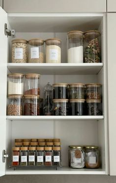 an organized pantry filled with lots of different types of spices and food in glass containers