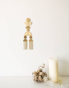 a white table topped with a candle next to a wall clock and some decorations on top of it