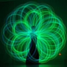 a person standing in front of a green object with light painting on it's face