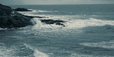 waves crashing into the shore on an overcast day