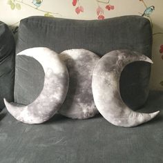 two moon pillows sitting on top of a bed