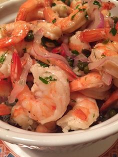 a white bowl filled with shrimp and onions