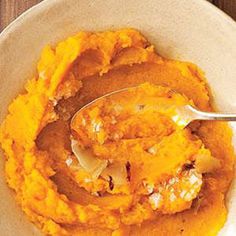 a bowl filled with mashed sweet potatoes and topped with a serving spoon in it