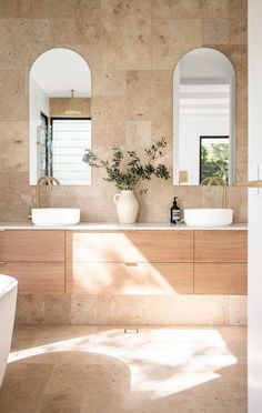 a bathroom with two sinks and mirrors on the wall