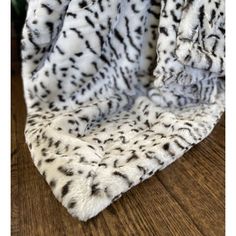 a white and black animal print blanket on top of a wooden table