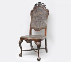 an ornate wooden chair against a white background with no one in the room to see it