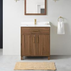 a bathroom with a sink, mirror and towel rack on the wall next to it