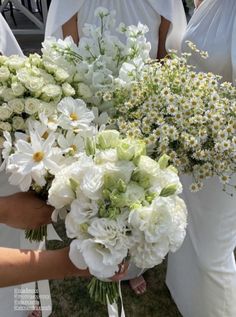 the bridesmaids are holding bouquets of white flowers