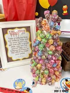 there is a candy tree on the table next to a sign and some candies