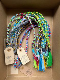 a box filled with lots of different colored beads and tags attached to each strander