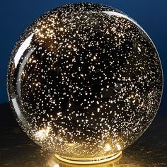 a glass ball with stars on it sitting on a table