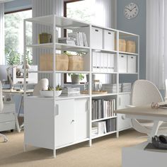 an office with white furniture and lots of books