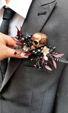 a person wearing a suit and tie with a skull brooch