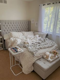 an unmade bed in a bedroom with white linens and pillows on top of it