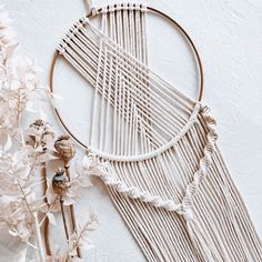 a close up of a macrame and flowers on a white surface with an object in the background