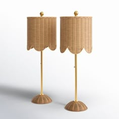 two lamps with wicker shades on each side and one light is turned on the other