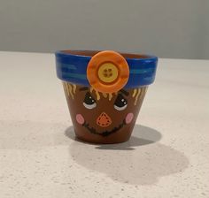 a ceramic cup with a face painted on it