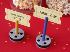 two popcorn poppers are sitting on top of each other, with labels reading movie theater butter