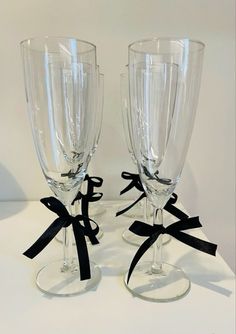 two wine glasses with black bows on them