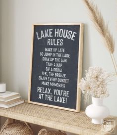 a sign that says lake house rules on it next to some baskets and a vase