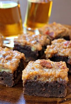 some brownies and two glasses of beer on a table