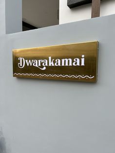 a sign on the side of a building that says dwarakamai in white and gold