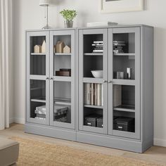 a grey bookcase with glass doors in a living room