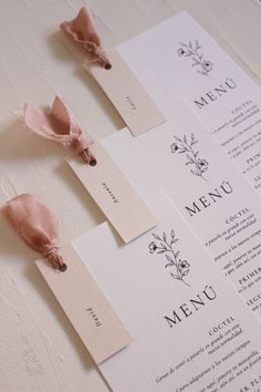 the menus are laid out on top of each other, with pink napkins attached to them