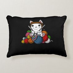 a black pillow with a cartoon cat holding a ball of yarn