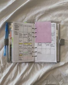 an open planner book with notes and pens