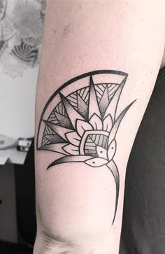 a black and white photo of a tattoo on someone's left arm with an abstract design