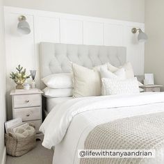 a bed with white sheets and pillows in a bedroom