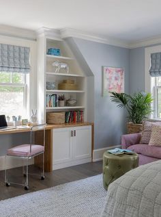 a bedroom with a desk, chair and bookshelf next to a couch in front of a window