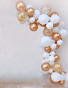 white, gold and silver balloons are hanging from the ceiling in front of a staircase