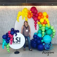 a woman standing in front of a wall with balloons and a sign that says lsi rockster