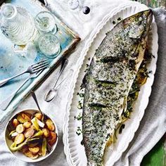 an image of fish on a plate with nuts and water in the bowl next to it